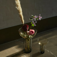 Glass vase setup featuring earthy tones, vibrant pinks, deep burgundy, and soft greens with elegant floral patterns.