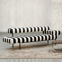 Black and white striped sofa with modern design, featuring bold patterns against a neutral background.