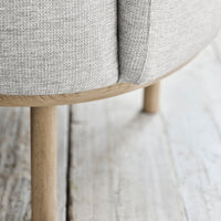 Light gray fabric with subtle texture, complemented by natural wood legs. Modern, minimalist design.