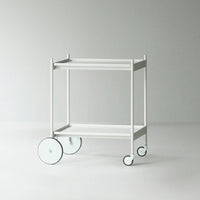 White rolling cart with minimalistic design and round black-accented wheels, perfect for modern decor.
