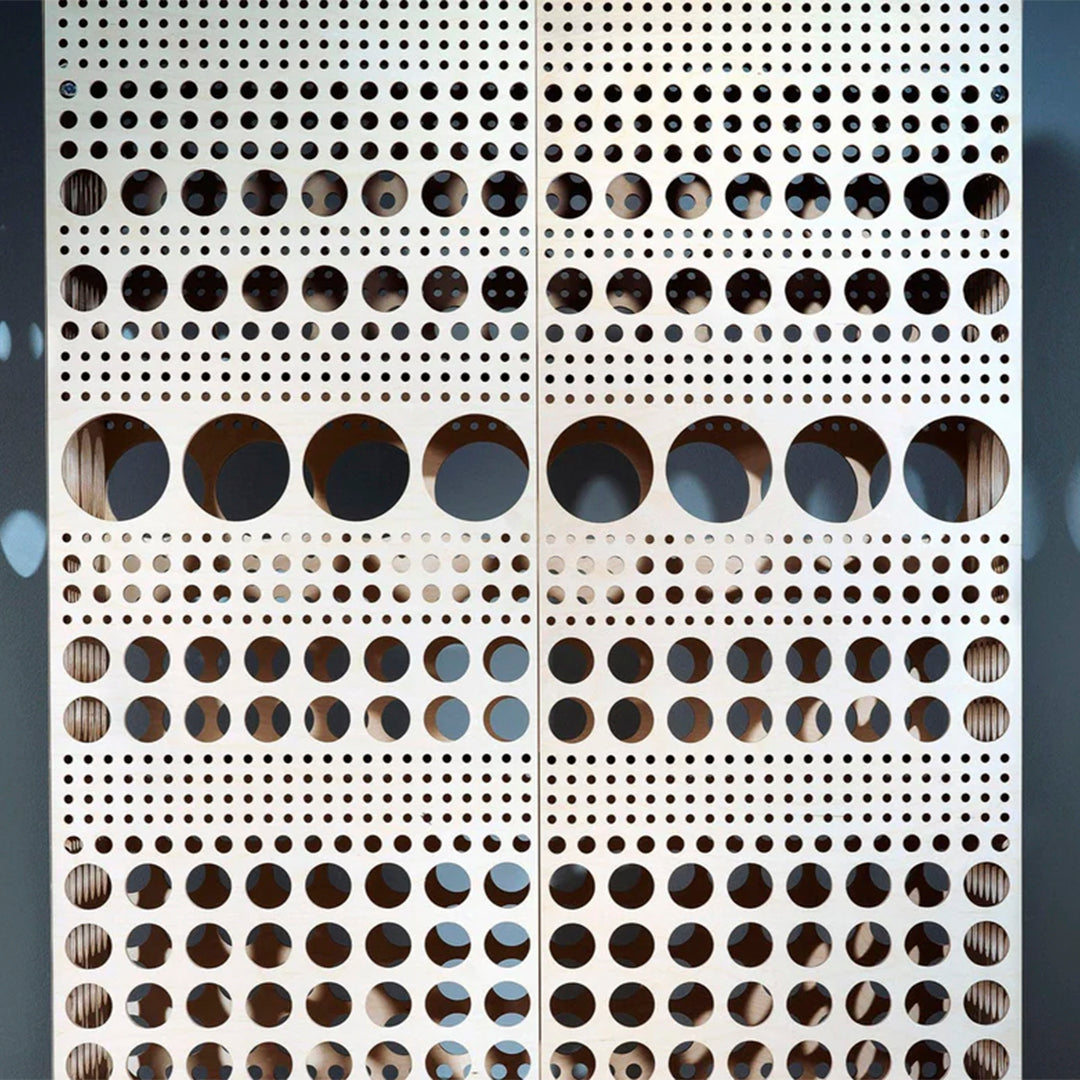 Patterned wooden panel featuring a mix of small and large circular cutouts in a light wood finish.