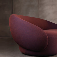 Textured armchair in deep maroon and violet hues, featuring a modern rounded design and intricate knit pattern.