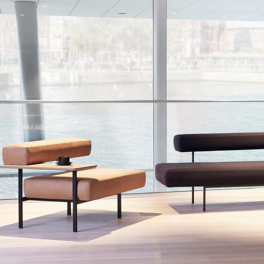 Modern lounge seating featuring warm tan and rich dark brown upholstery with sleek black metal legs.