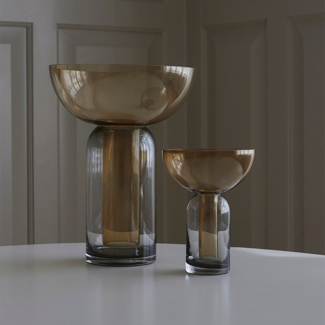 "Elegant brown and gray glass vases with smooth, modern silhouettes and subtle color gradients."
