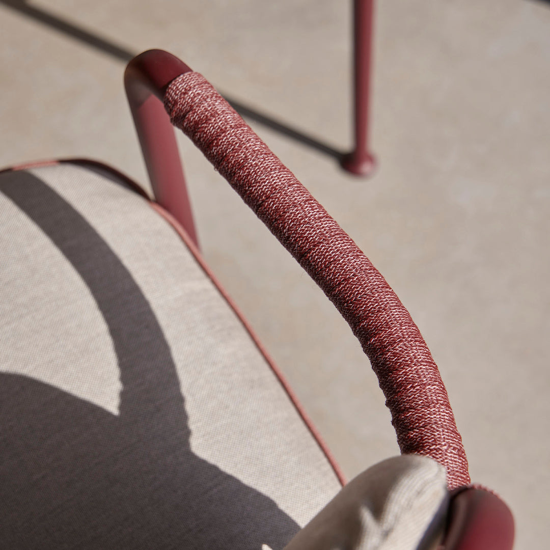 "Soft beige cushion with textured burgundy armrest, featuring a modern shadow pattern."