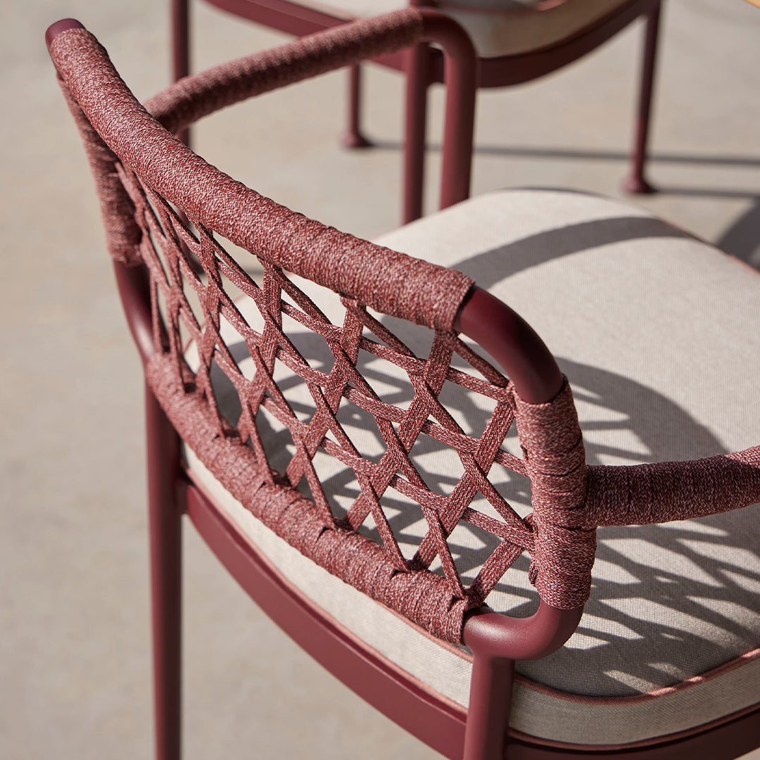 Rust-colored woven chair back with beige cushion, featuring a geometric pattern and smooth finish.