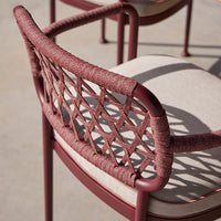 Rust-colored woven chair back with beige cushion, featuring a geometric pattern and smooth finish.