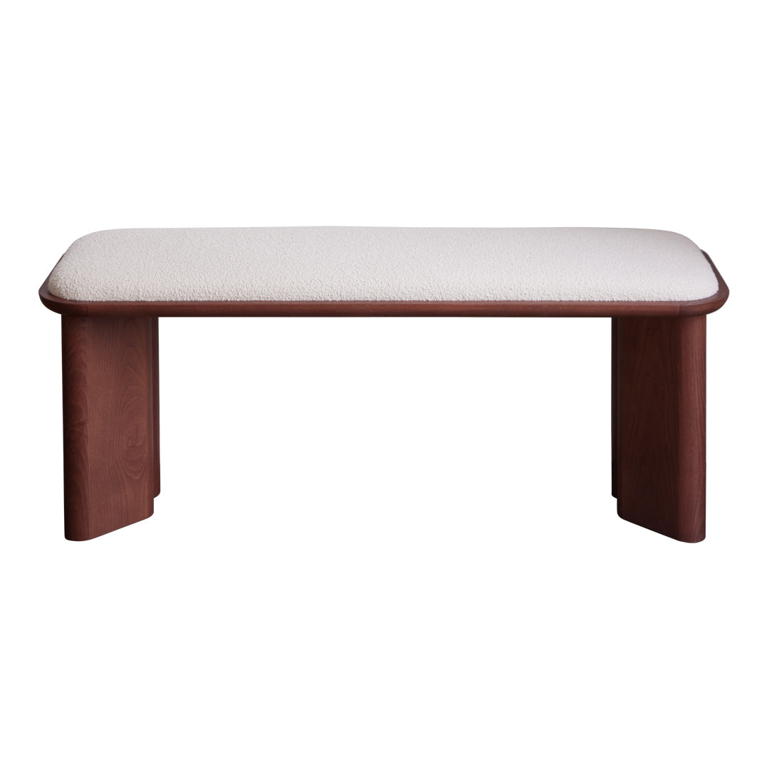 Brown wooden bench with a light beige, textured upholstered cushion on top, featuring a minimalist design.
