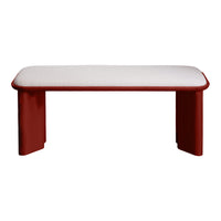 Red bench with smooth, rounded edges and a soft white cushion on top, perfect for modern decor.