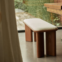Natural wood bench with a soft beige cushion, minimalistic design, and smooth lines, perfect for modern decor.