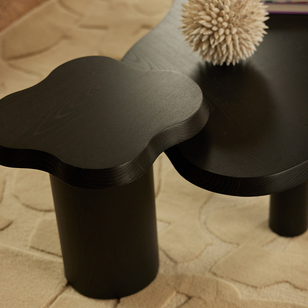 Black cloud-shaped end table with a smooth finish, featuring rounded edges and a minimalist design.