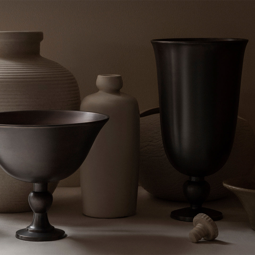"Variety of textured vases in earthy tones, featuring dark and neutral colors with elegant shapes and smooth finishes."