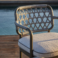 "Gray woven chair with diamond lattice pattern and light gray cushioned seat, perfect for outdoor decor."