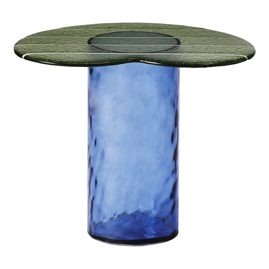Blue glass table with a green, textured circular top and a transparent center. Modern design with vibrant colors.