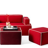 Red sofa with cream trim and matching red and burgundy ottomans, showcasing vibrant colors and textures.