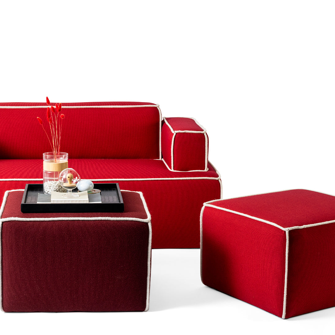 Bold red sofa and ottomans with contrasting white piping and deep burgundy accents, perfect for modern decor.
