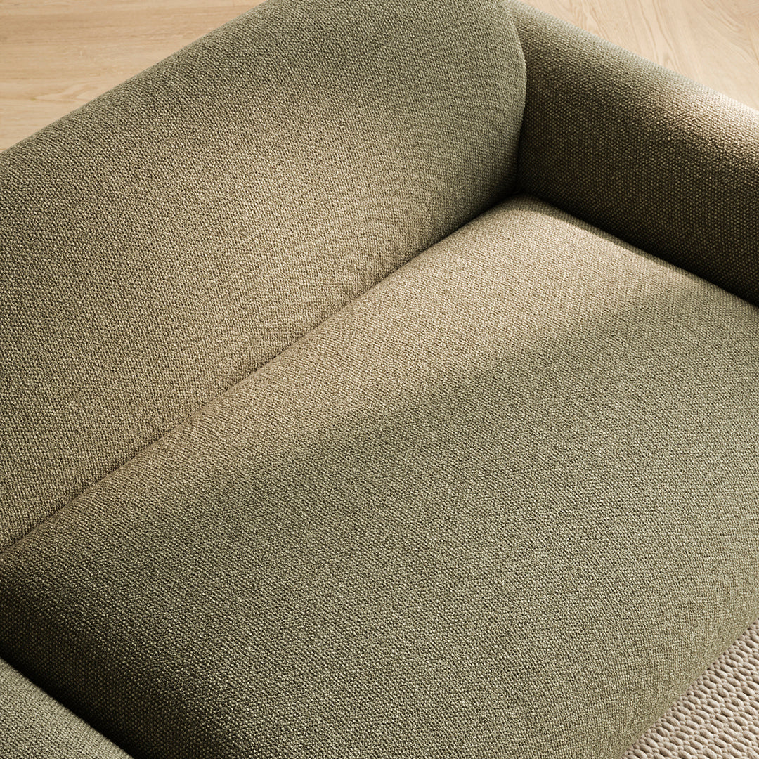 Olive green textured upholstery on a modern sofa, showcasing subtle patterns and a cozy, inviting look.