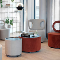 Gray and rust upholstered seating with circular patterns, featuring a metallic table and light wood flooring.