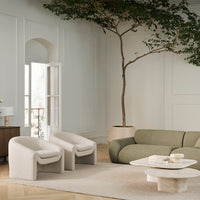 Soft beige and muted green seating with textured patterns in a cozy, light-filled modern living space.