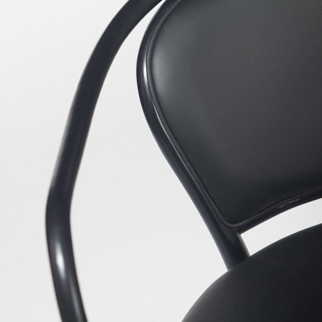 Black upholstered chair with smooth, glossy finish and sleek, curved metal frame. Ideal for modern decor.