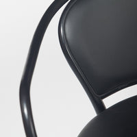 Black upholstered chair with smooth, glossy finish and sleek, curved metal frame. Ideal for modern decor.
