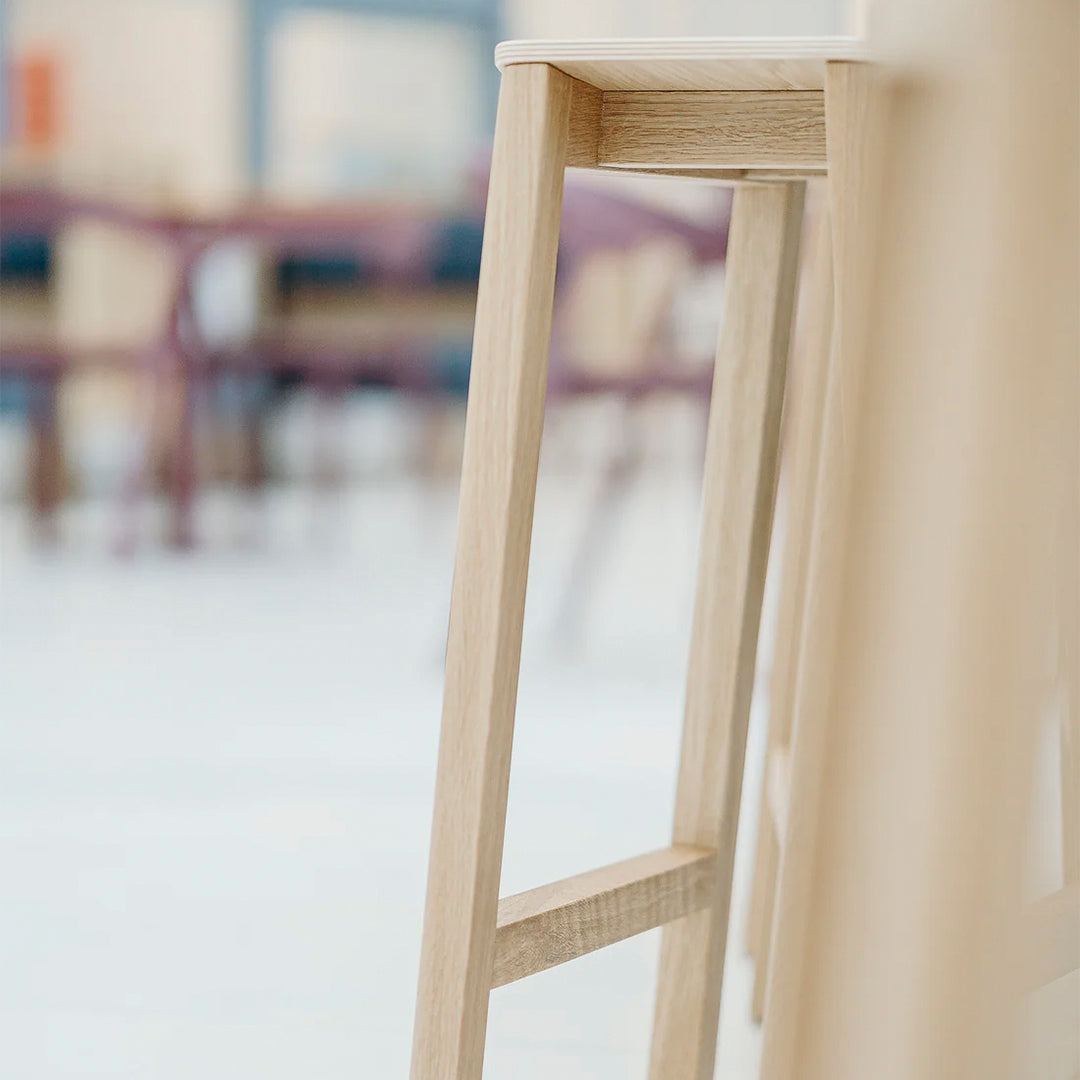 Light natural wood barstool leg with minimalist design, featuring smooth textures and subtle grain patterns.