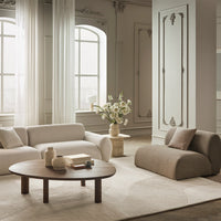 Neutral-toned living room with soft beige and brown furnishings, featuring textured fabrics and subtle geometric patterns.