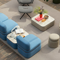 Blue upholstered seating with orange accents, geometric black and white patterns, and a neutral textured rug.