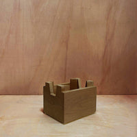 Rustic brown wooden block with a simple, smooth design against a warm, textured background.