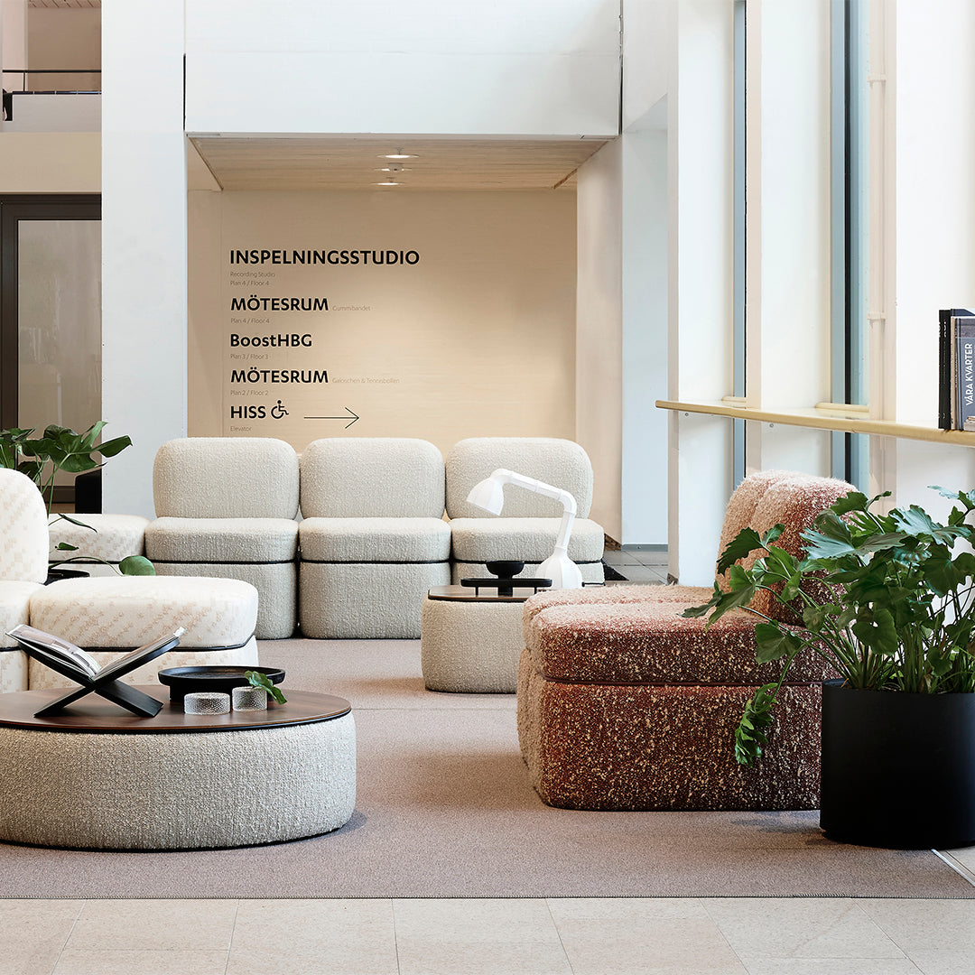 Textured cream and pink upholstered furniture with soft hues in a modern, minimalist interior setting.