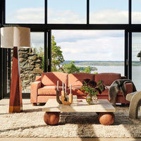 "Soft pink sofa, neutral textures, earthy tones, and geometric patterns complementing a serene natural backdrop."