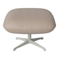 Beige leather ottoman with a smooth texture and a minimalist white base. Ideal for modern decor.