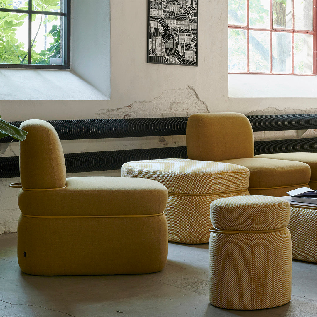 Stylish yellow upholstered chairs and ottomans with textured patterns, enhancing modern decor.