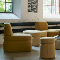 Yellow upholstered chairs and poufs with textured patterns in a modern interior setting.