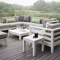 Outdoor seating set with gray cushions and green striped accent pillows, featuring white frames and a wooden deck.