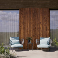 Light blue cushions on modern chairs, set against rich wood paneling and soft, neutral surroundings.