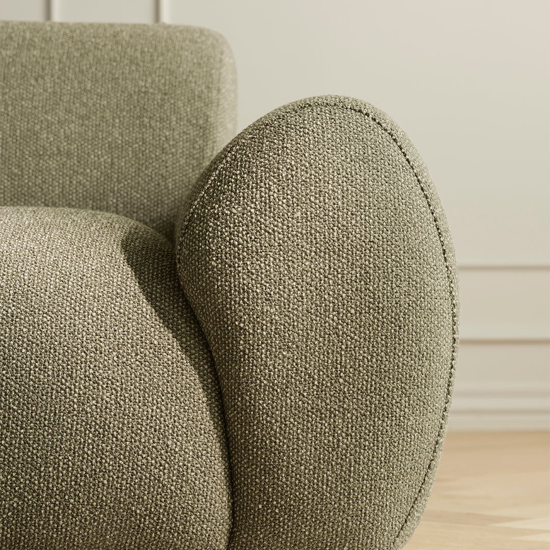 Textured olive green fabric upholstery with a rounded arm design, highlighting subtle variations in tone.