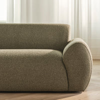 Textured olive green sofa fabric with a smooth, rounded armrest and subtle pattern. Bright, airy setting.