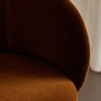Warm brown velvet fabric with smooth, curved contours and subtle stitched detailing. Perfect for a cozy atmosphere.