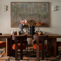 Elegant dining room with earthy tones, vibrant orange accents, textured patterns, and soft neutral backgrounds.