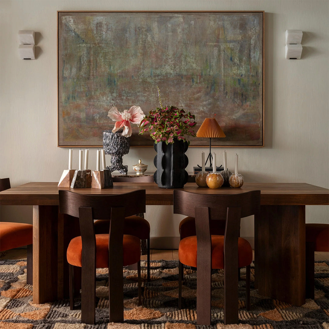 Stylish dining area featuring earthy tones, rich browns, vibrant oranges, and textured patterns in upholstery and decor.