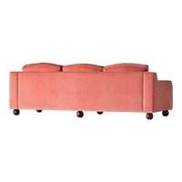 Blush pink velvet sofa with plush back cushions and dark wooden legs. Stylish and modern design for any living space.