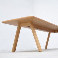 Light wooden table with a smooth, natural finish and sleek, minimalist design.