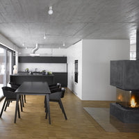 Modern dining room featuring sleek black furniture, concrete ceiling, and warm wood flooring, creating a contemporary aesthetic.