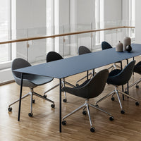Stylish dark blue table with gray upholstered chairs on a wooden floor, featuring sleek, modern lines and minimal patterns.