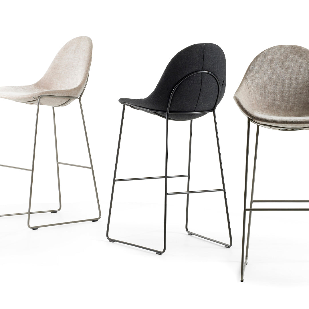 Set of three modern bar stools in light beige, dark gray, and medium gray upholstery with sleek metal legs.
