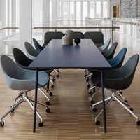 Modern conference table featuring a navy blue surface, paired with gray and blue armchairs in a minimalist setting.