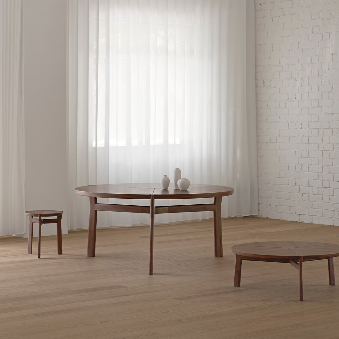 Wooden coffee and side tables in rich brown tones against a light, airy backdrop with white sheer curtains.