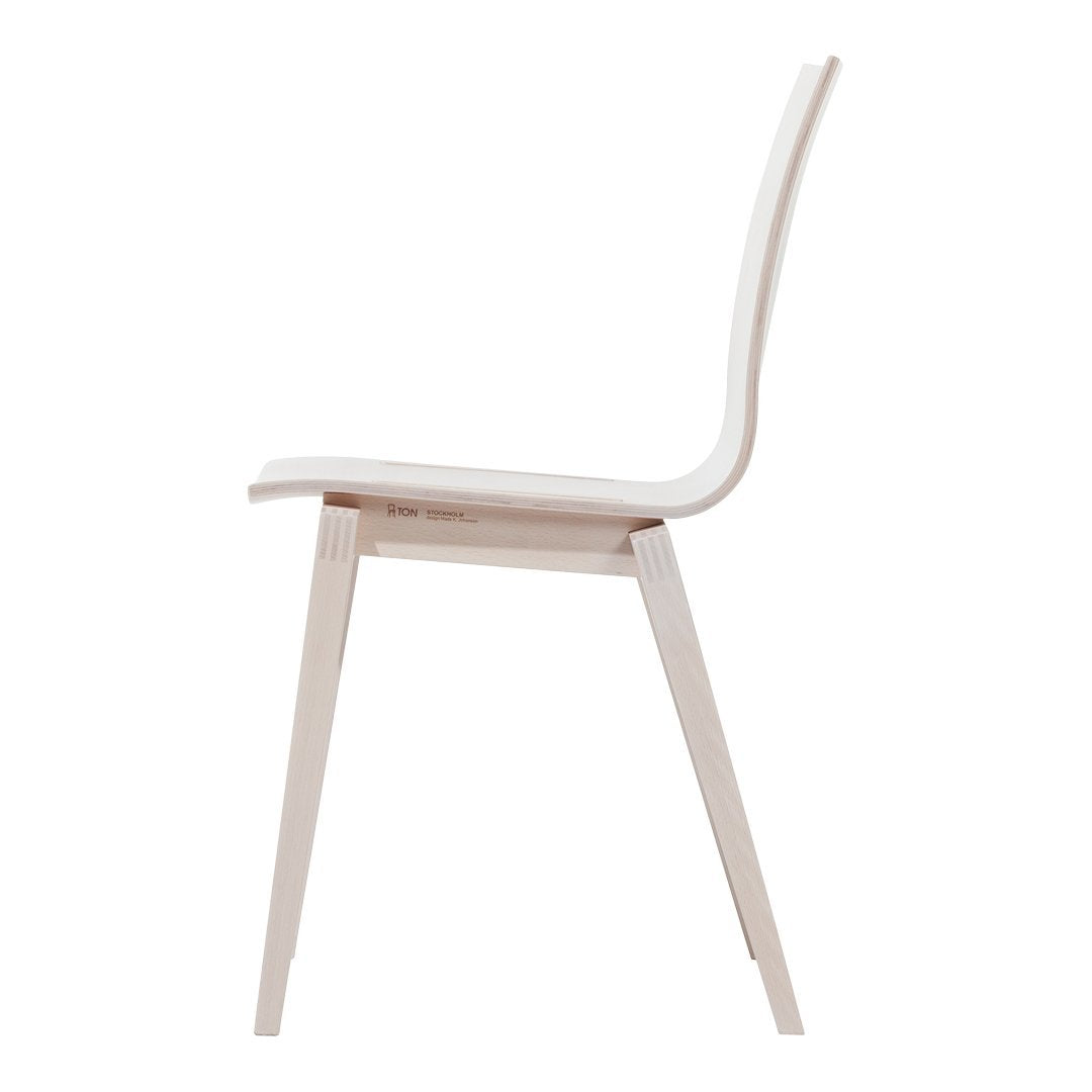 Minimalist white chair with smooth curves and natural wood legs, showcasing a simple, modern design.