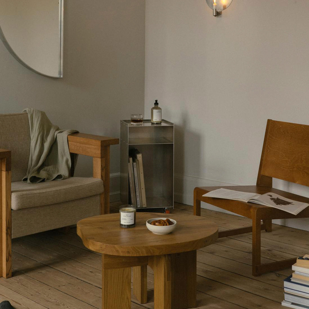 Natural wood tones with a minimalist design, featuring a circular tabletop and simple, modern seating.